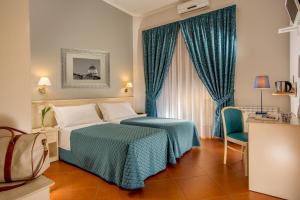 a hotel room with a bed and a chair and a window at Ottaviano Guest House in Rome