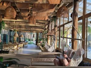 a room with two hammocks and tables and chairs at Cocohut Beach Resort Koh Phangan in Haad Rin