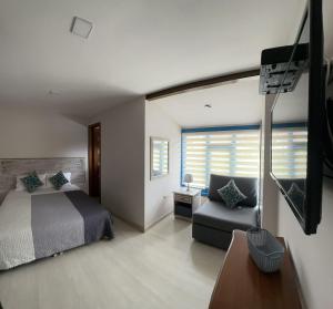 a bedroom with a bed and a chair and a television at La Casa Azul in Cuenca