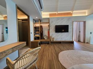 a living room with a flat screen tv on a wall at Cocohut Beach Resort Koh Phangan in Haad Rin