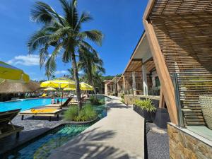 a resort with a swimming pool with a palm tree at Cocohut Beach Resort Koh Phangan in Haad Rin