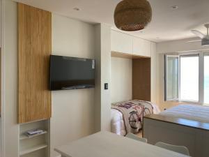une chambre d'hôtel avec un lit et une télévision à écran plat dans l'établissement Ventana al mar, à Mar del Plata