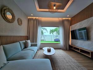 a living room with a blue couch and a tv at Cocohut Beach Resort Koh Phangan in Haad Rin
