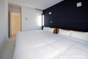 Una gran cama blanca en una habitación con una pared negra. en Mist, en Sapporo 61 fotos más