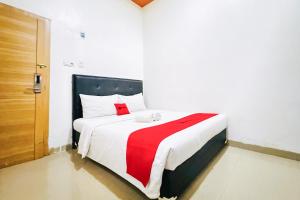 Postel nebo postele na pokoji v ubytování RedDoorz at Jalan Basuki Rahmat Palembang