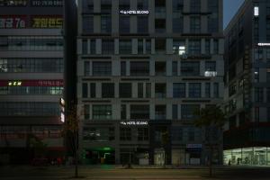 a tall white building with signs on it at night at Aank Hotel Sejong in Sejong