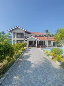 a house with a walkway in front of a building at Villa in Chilaw