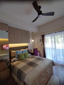 Un dormitorio con una cama con ventilador de techo. en Lauriz Place at Amani Grand Resort and Residences, en Lapu Lapu City