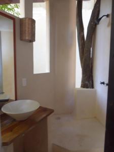 un bagno con lavandino e un albero nell'angolo di Siesta Fiesta Tree house a Playa del Carmen