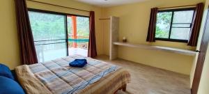 a bedroom with a bed and a large window at Alisa Bungalows in Ko Chang