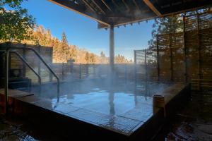 a hot tub in a house with smoke in it at Fukuichi in Shibukawa