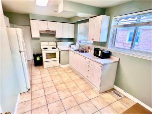 a kitchen with white appliances and a tile floor at Dar-09 Room Near Airport in Brampton