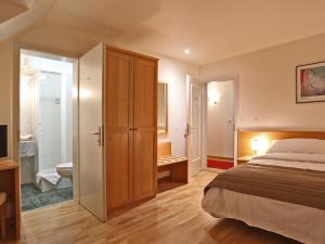 a bedroom with a bed and a bathroom at Hôtel du Cheval Blanc - City center in Bulle