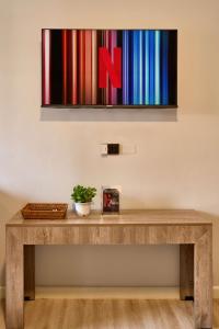 a wooden table with a painting on the wall at Thapae60 Mini Hotel in Chiang Mai