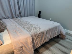 Una cama en un dormitorio con colcha. en 2 bedroom basement Suite, en Edmonton