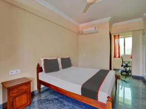 a bedroom with a bed and a desk in it at Family Castle Hotel in Trivandrum