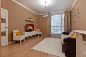 a living room with a couch and a tv at Абрикосовое парфе in Astana