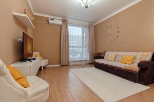 a living room with a couch and a clock on the wall at Абрикосовое парфе in Astana