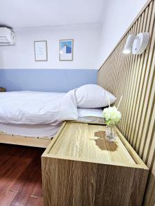 a bedroom with a bed and a table with a vase of flowers at Seoul Nest in Seoul