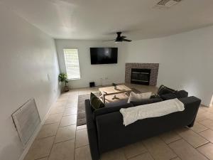 a living room with a black couch and a fireplace at Newly updated house on huge lot in North Port