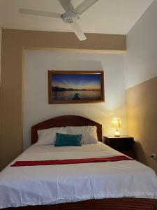 a bedroom with a bed with a blue pillow on it at Emanuel&Cavita in Iquitos +40 photos