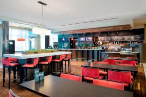 a restaurant with red chairs and tables and a bar at Courtyard by Marriott Miami Homestead in Homestead