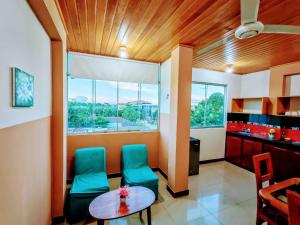 a room with two green chairs and a table at Emanuel&Cavita in Iquitos