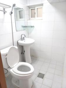 a white bathroom with a toilet and a sink at Seoul Nest in Seoul