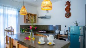 a kitchen with a table and a blue refrigerator at Blissful House Two Bedroom Apartment Thalpe Beach in Galle