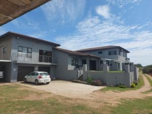 a house with a car parked in front of it at Hlophe's Place in Hibberdene