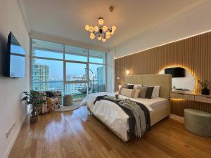 Un dormitorio con una cama grande y una ventana grande. en Opulent Flat with Beach, Pool & Canal View in JBR, en Dubái