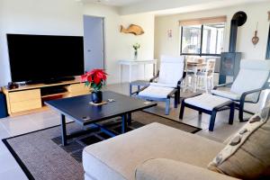 un soggiorno con tv e tavolo di 31A Enjoy Your Stay a Orford