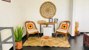 a living room with two chairs and a table at Lake Ibis in Tissamaharama