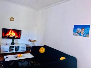 a living room with a black couch and a fireplace at Vuyomat Guest House 1 in Gqeberha