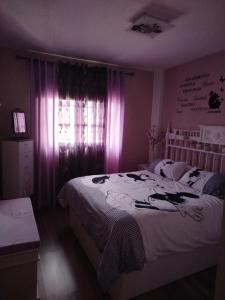 a bedroom with a bed and a window with purple lighting at Mi Rincón Favorito in Adeje