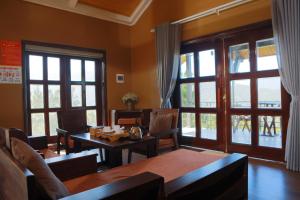 a dining room with a table and chairs and windows at Cloud Paradise Resort in Lao Cai