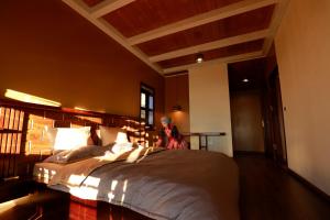 a woman sitting on a large bed in a room at Cloud Paradise Resort in Lao Cai