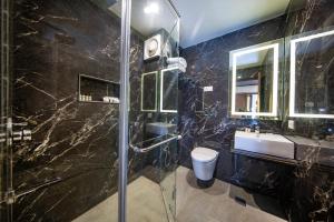 un bagno con doccia, lavandino e specchio di Solar Residency, Srinagar a Srinagar