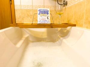 a bath tub filled with water with a bottle and a glass of wine at Panorama View-Stoykite in Stoykite +38 photos