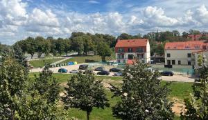 Blick auf einen Park mit Autos und Gebäuden in der Unterkunft Memel Town Apartments in Klaipėda