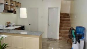 a kitchen with a counter and a staircase in the background at PabDig Townhouse in Dauis