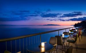 a row of tables on a balcony with a view of the water at Boutique & Design Hotel Navis - Small Luxury Hotels of the World in Opatija