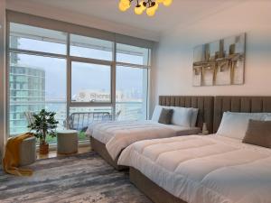 Dos camas en una habitación con una gran ventana. en Opulent Flat with Beach, Pool & Canal View in JBR, en Dubái 37 fotos más