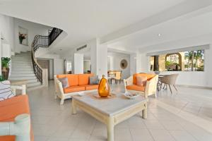 a living room with orange couches and a table at Seafront Villa - Puerto Vallarta in Puerto Vallarta