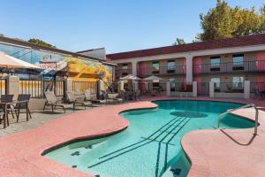 un hôtel avec une piscine devant un immeuble dans l'établissement Days Inn by Wyndham Memphis at Graceland, à Memphis