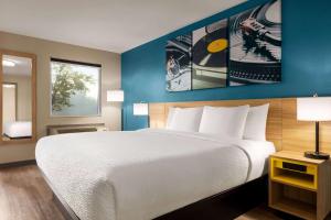 a bedroom with a large white bed and blue walls at Days Inn by Wyndham Memphis at Graceland in Memphis +18 photos