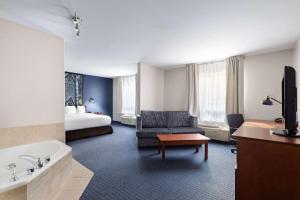 圣阿加瑟莫速8圣阿加特酒店的带浴室的酒店房间，浴室配有床和浴缸