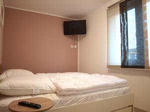 a bedroom with two beds with a tv on the wall at Ferienwohnung Graal Müritz im Igelring in Graal-Müritz