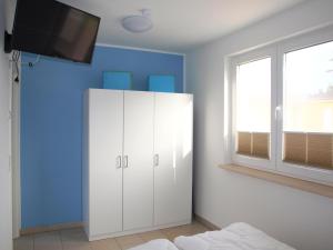 a bedroom with a white cabinet and a tv on the wall at Ferienwohnung Graal Müritz im Igelring in Graal-Müritz