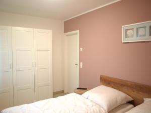 Schlafzimmer mit einem Bett und weißen Schränken in der Unterkunft Ferienwohnung Graal Müritz im Igelring in Graal-Müritz